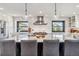 Modern kitchen boasts a large island with seating, stainless steel appliances, and designer lighting at 7388 S Ireland Cir, Centennial, CO 80016