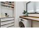 Laundry area with a wooden countertop, modern appliances, and custom shelving at 7388 S Ireland Cir, Centennial, CO 80016