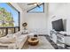 Modern living room with a large window, vaulted ceiling, white sectional sofa, and stylish decor at 7388 S Ireland Cir, Centennial, CO 80016