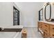 Modern bathroom with a standalone tub, wooden vanity, and modern light fixtures at 7388 S Ireland Cir, Centennial, CO 80016