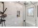 Modern tiled shower with built-in niche and bench in a bright, neutral color palette at 7388 S Ireland Cir, Centennial, CO 80016