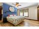 Bright bedroom features a unique blue accent wall, wood-trimmed windows, hardwood floors and stylish ceiling fan at 209 American Way, Breckenridge, CO 80424