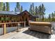 Exterior deck featuring a hot tub, wooden flooring, and views of a lush green forest at 209 American Way, Breckenridge, CO 80424
