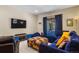 Comfortable living room area with a blue sectional couch, a large TV and access to the backyard at 209 American Way, Breckenridge, CO 80424