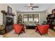 Comfortable living room with stone fireplace, large windows, and ceiling fan at 209 American Way, Breckenridge, CO 80424