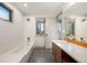 A bright bathroom features a modern vanity, tiled floor, and a tub with a shower at 424 Grape St, Denver, CO 80220