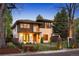 Beautifully landscaped two-story home featuring stone and wood facade, manicured lawn, and black metal fencing at 424 Grape St, Denver, CO 80220