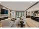 Open-concept living room with stone accent wall, fireplace, neutral furniture, and seamless flow to the kitchen at 424 Grape St, Denver, CO 80220