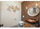 Chic powder room featuring decorative wall, vessel sink and unique lighting fixtures at 424 Grape St, Denver, CO 80220