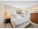 Bright bedroom featuring a large window, bedside table and lamp, dresser, and hardwood floors at 12354 W Nevada Pl # 102, Lakewood, CO 80228