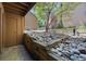 Landscaped outdoor patio featuring stone, wood, and surrounding greenery and buildings at 12354 W Nevada Pl # 102, Lakewood, CO 80228