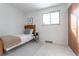 Cozy bedroom with a single bed, striped rug, wood headboard, and natural light from the window at 6526 S Cherry Way, Centennial, CO 80121