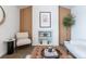 Living room area with a modern chair, leather ottoman, stylish decor, and wood slat accent walls at 6526 S Cherry Way, Centennial, CO 80121