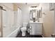 A clean bathroom with white tile, a tub, and modern fixtures at 9316 Harrison St, Thornton, CO 80229
