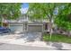 Inviting front exterior featuring a two-story townhome with a two car garage and mature landscaping at 9316 Harrison St, Thornton, CO 80229
