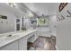 A bright bathroom features a double sink vanity, sleek wood flooring, and a separate shower and tub at 18647 E Berry Dr, Aurora, CO 80015