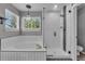 The bathroom includes a shower with glass doors and a white tiled tub, illuminated by natural light at 18647 E Berry Dr, Aurora, CO 80015