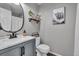 Bathroom featuring grey vanity, round mirror and framed artwork at 18647 E Berry Dr, Aurora, CO 80015
