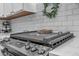 Close up of stainless gas cooktop, quartz counters and subway tile backsplash at 18647 E Berry Dr, Aurora, CO 80015