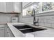 Close up of undermount sink, quartz counters, subway tile backsplash and stainless faucet at 18647 E Berry Dr, Aurora, CO 80015