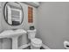 The powder room features a unique pedestal sink and a baseball themed sign above the toilet at 18647 E Berry Dr, Aurora, CO 80015