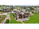 Aerial view of a luxurious home with a stone and stucco exterior, a spacious deck, and lush landscaping at 2466 Spruce Meadows Dr, Broomfield, CO 80023