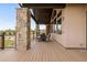 Back deck with wood flooring, stone pillars, ceiling fan, and outdoor furniture with views of the backyard at 2466 Spruce Meadows Dr, Broomfield, CO 80023