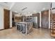 Basement bar area with a granite island, stainless steel refrigerator, bar stools, and wine storage at 2466 Spruce Meadows Dr, Broomfield, CO 80023