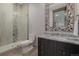 Modern bathroom with tiled shower, mosaic mirror, and granite countertop at 2466 Spruce Meadows Dr, Broomfield, CO 80023