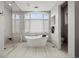 Bright bathroom showcasing a soaking tub, glass shower, and large window with privacy shades at 2466 Spruce Meadows Dr, Broomfield, CO 80023