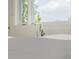 Close-up of a modern white bathtub with sleek faucet and a view from the window at 2466 Spruce Meadows Dr, Broomfield, CO 80023