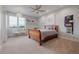 Bedroom with light gray walls, plush carpet, a wooden bed frame, and natural light from large window at 2466 Spruce Meadows Dr, Broomfield, CO 80023