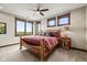 Comfortable bedroom with wood-frame bed, bedside table, plush carpet, and three large windows at 2466 Spruce Meadows Dr, Broomfield, CO 80023