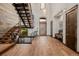 Inviting home foyer with hardwood floors, high ceilings, custom metal stairs, and a large wood front door at 2466 Spruce Meadows Dr, Broomfield, CO 80023