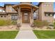 Elegant front door featuring a stone facade, modern design, and professional landscaping at 2466 Spruce Meadows Dr, Broomfield, CO 80023