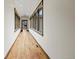 Long hallway featuring hardwood floors, rustic wood trim, and multiple windows allowing natural light at 2466 Spruce Meadows Dr, Broomfield, CO 80023