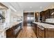 Spacious kitchen featuring dark wood cabinetry, stainless appliances, and beautiful marble countertops at 2466 Spruce Meadows Dr, Broomfield, CO 80023