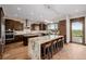 Gourmet kitchen featuring granite countertops, stainless steel appliances, dark-wood cabinets, and an oversized island at 2466 Spruce Meadows Dr, Broomfield, CO 80023