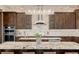Elegant kitchen with a granite countertop island, stainless steel appliances, and custom cabinetry at 2466 Spruce Meadows Dr, Broomfield, CO 80023