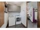 Modern laundry room features gray cabinets, washer, and dryer, with a hallway leading to a desk area at 2466 Spruce Meadows Dr, Broomfield, CO 80023