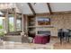 Cozy living area with stone fireplace, built-in shelves, a piano, and expansive windows for natural light at 2466 Spruce Meadows Dr, Broomfield, CO 80023