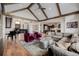 Stylish living room featuring hardwood floors, a piano, designer seating, and seamless kitchen access at 2466 Spruce Meadows Dr, Broomfield, CO 80023