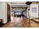 Open living room with hardwood floors, exposed beams, stone fireplace, and large windows with a view at 2466 Spruce Meadows Dr, Broomfield, CO 80023