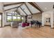 Open living area with vaulted ceilings, wood beams, stone accent wall, piano, and large windows at 2466 Spruce Meadows Dr, Broomfield, CO 80023