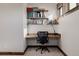 Office with wooden desk and shelves, black office chair and light colored carpet at 2466 Spruce Meadows Dr, Broomfield, CO 80023