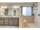 Bathroom featuring double sinks, tiled shower with seating, and a window for natural light at 601 E 131St Ct, Thornton, CO 80241