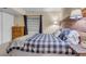 Comfortable bedroom with a buffalo check comforter, rustic wood headboard, and soft, neutral walls at 601 E 131St Ct, Thornton, CO 80241