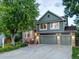 Inviting two-story home with a manicured lawn, a three-car garage, and a charming brick and wood facade at 601 E 131St Ct, Thornton, CO 80241