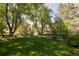Lush backyard with green grass, mature trees and beautiful landscaping at 3935 Pierson St, Wheat Ridge, CO 80033