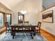 Light-filled dining room features a rustic wood table, stylish chandelier, and adjacent kitchen at 3935 Pierson St, Wheat Ridge, CO 80033